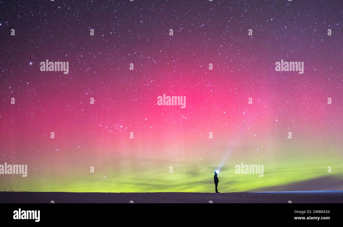 Escursionista solitario sotto l'aurora boreale nel cielo notturno, Long Creek, Prince Edward Island, Canada Foto Stock