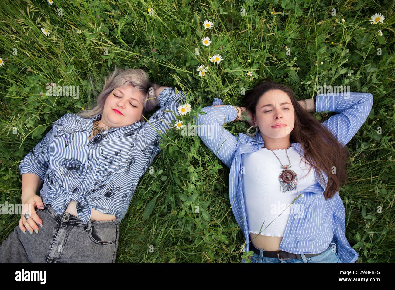 Due giovani donne riposano sull'erba, vista dall'alto Foto Stock