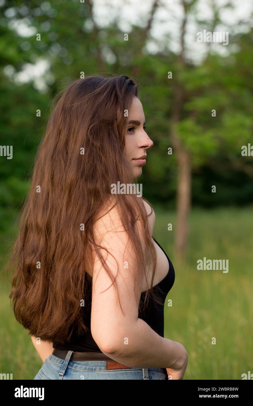 Ritratto di una bella bruna dai capelli lunghi in natura Foto Stock