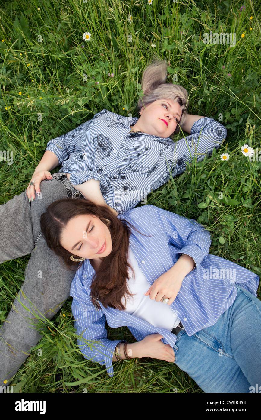 Due donne riposano sull'erba del parco, vista dall'alto Foto Stock