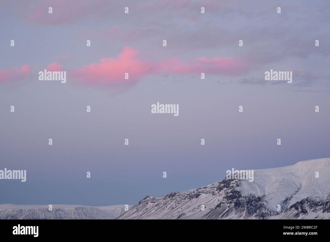 Cresta innevata sotto il cielo nuvoloso Foto Stock