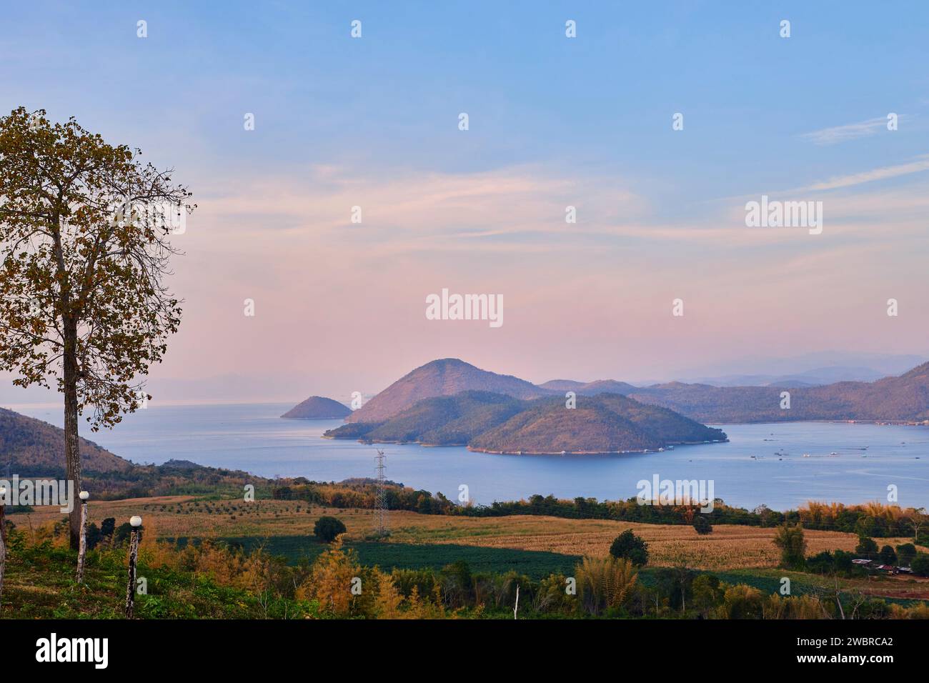 Vista panoramica del tramonto sulla diga con la montagna tropicale Foto Stock