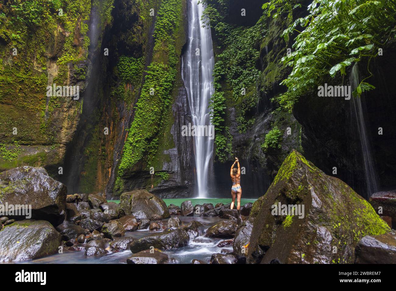 Una giovane donna in costume da bagno sta posando alla cascata nascosta vicino a Sekumpul, isola di Bali, Indonesia Foto Stock