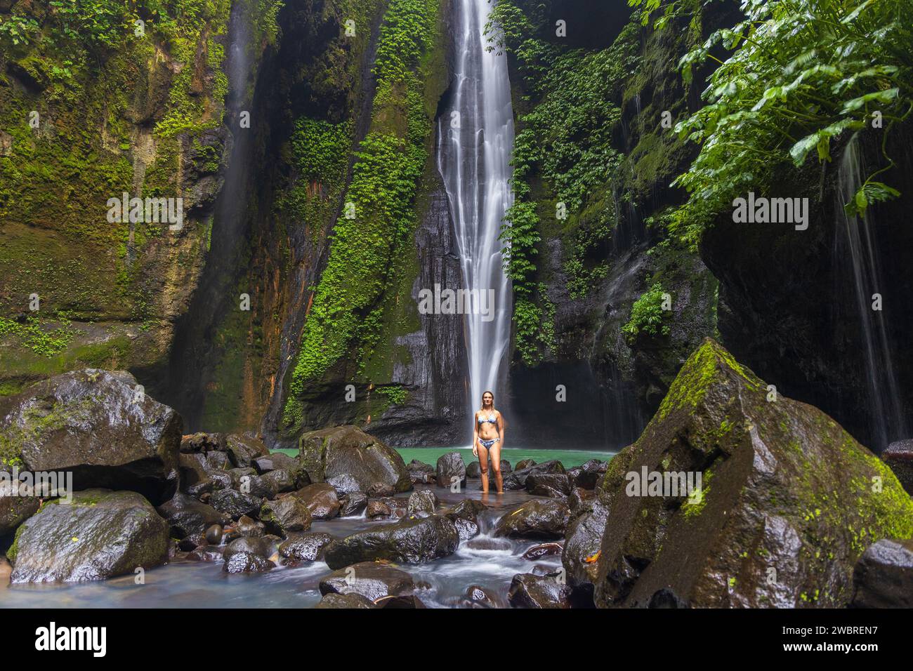 Una giovane donna in costume da bagno sta posando alla cascata nascosta vicino a Sekumpul, isola di Bali, Indonesia Foto Stock