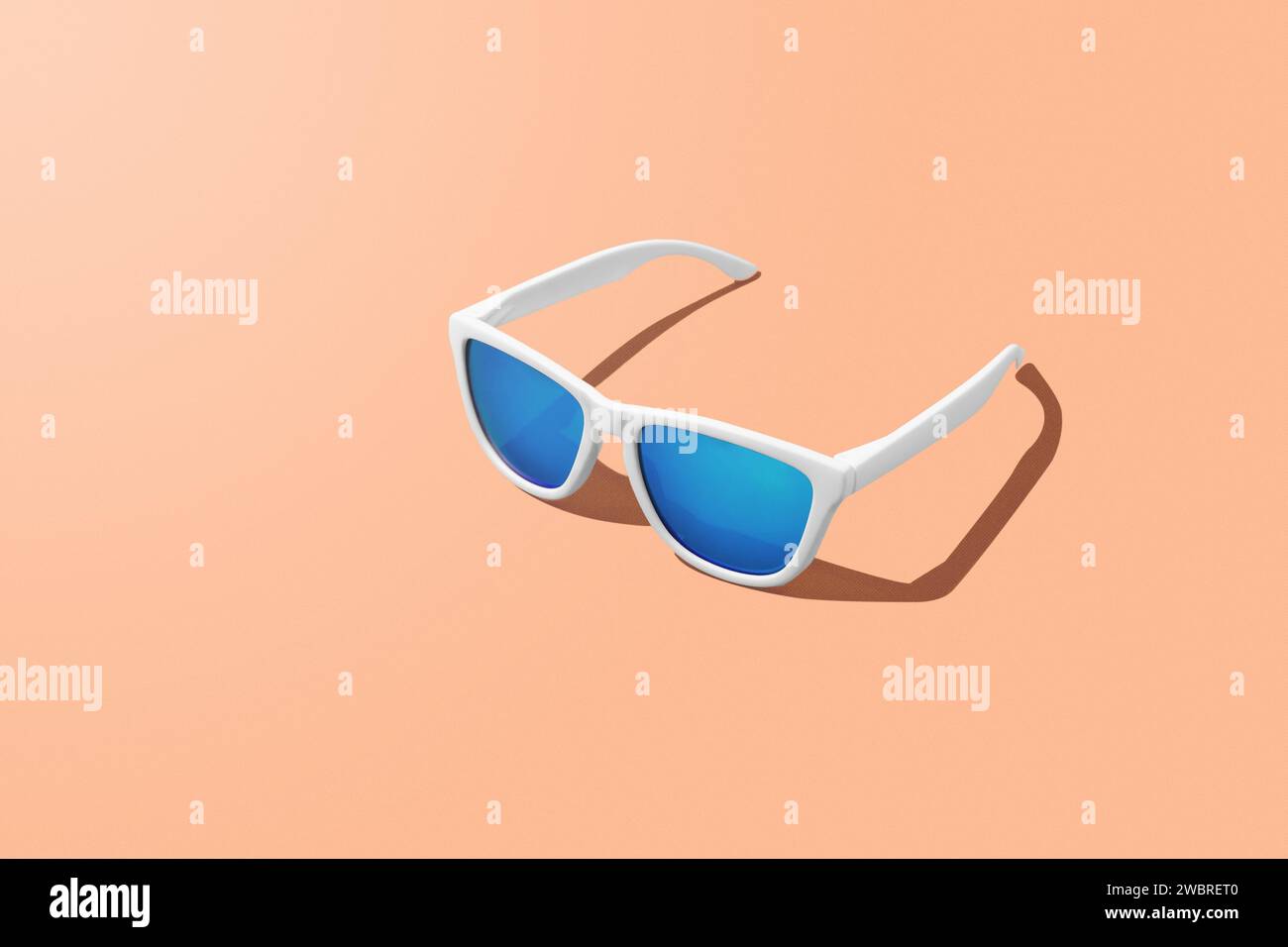 Rappresentazione 3D degli occhiali da sole blu su Peach Fuzz colore dell'anno sfondo e spazio per copiare. Foto studio. Banner di intestazione per promozioni e siti Web. Foto Stock
