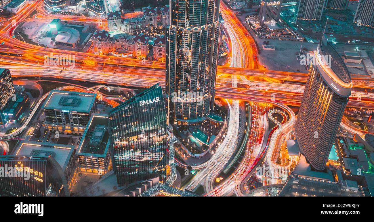 Dubai, Emirati Arabi Uniti - 21 febbraio 2021: Traffico cittadino sotto la Khalifa Tower. Visualizzazione iperlapse 4k dal punto di vista sul Burj Khalifa. Luci e spie illuminazione della linea. Sera Foto Stock