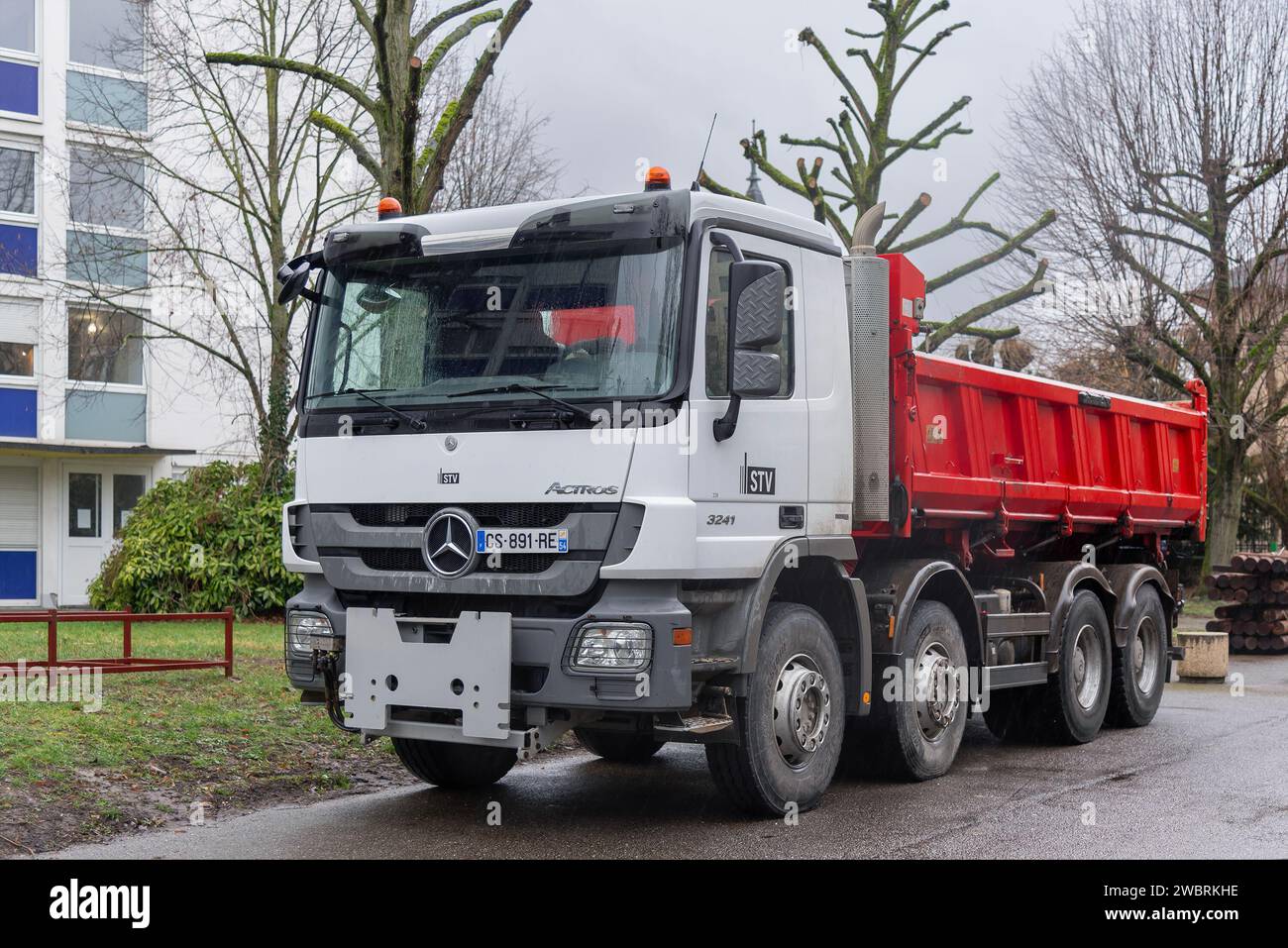 Nancy, Francia - dumper bianco e rosso Mercedes-Benz Actros 3241 in cantiere. Foto Stock