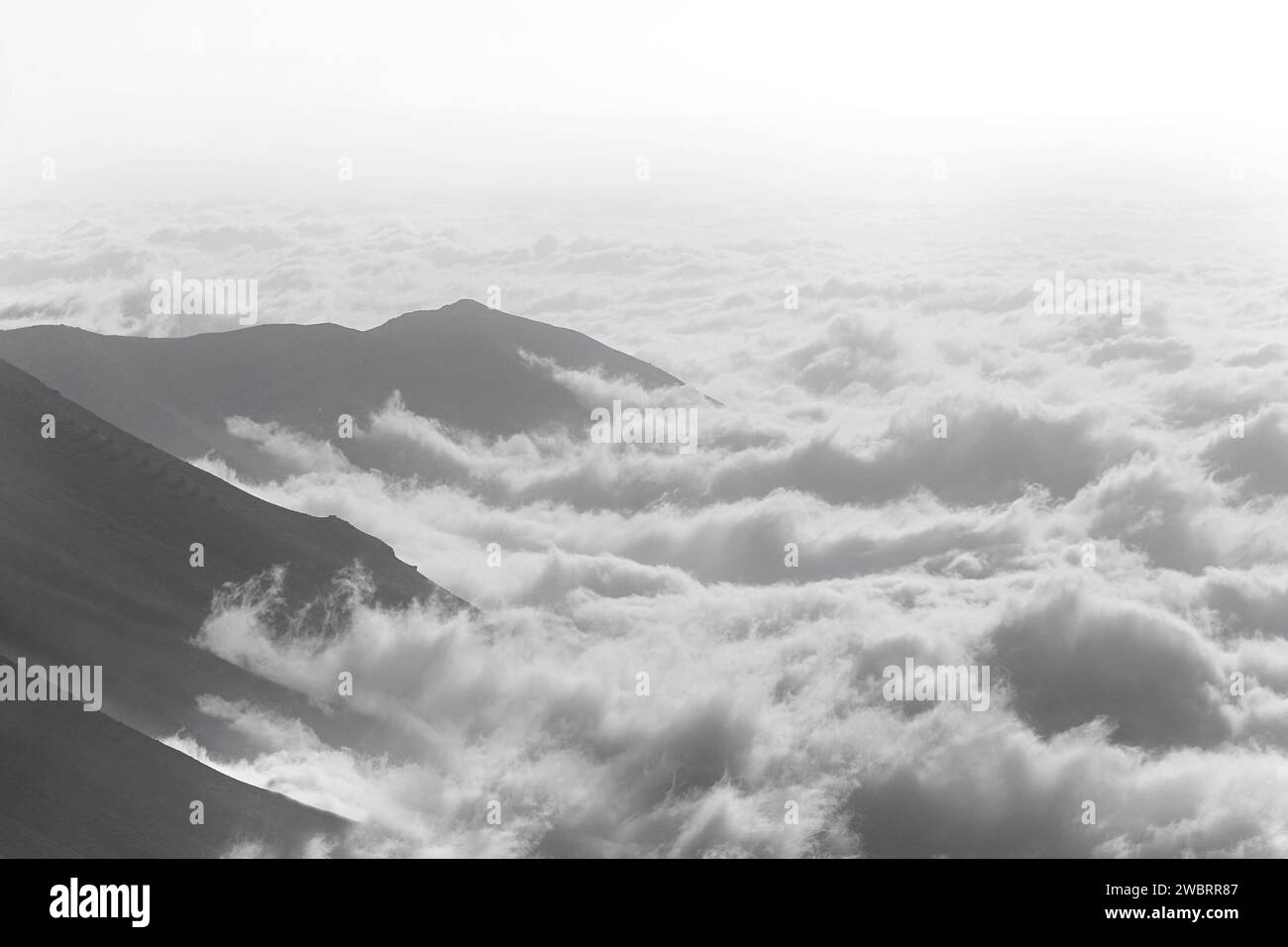 Nebbia che si insinua sulle montagne, in bianco e nero. Foto Stock