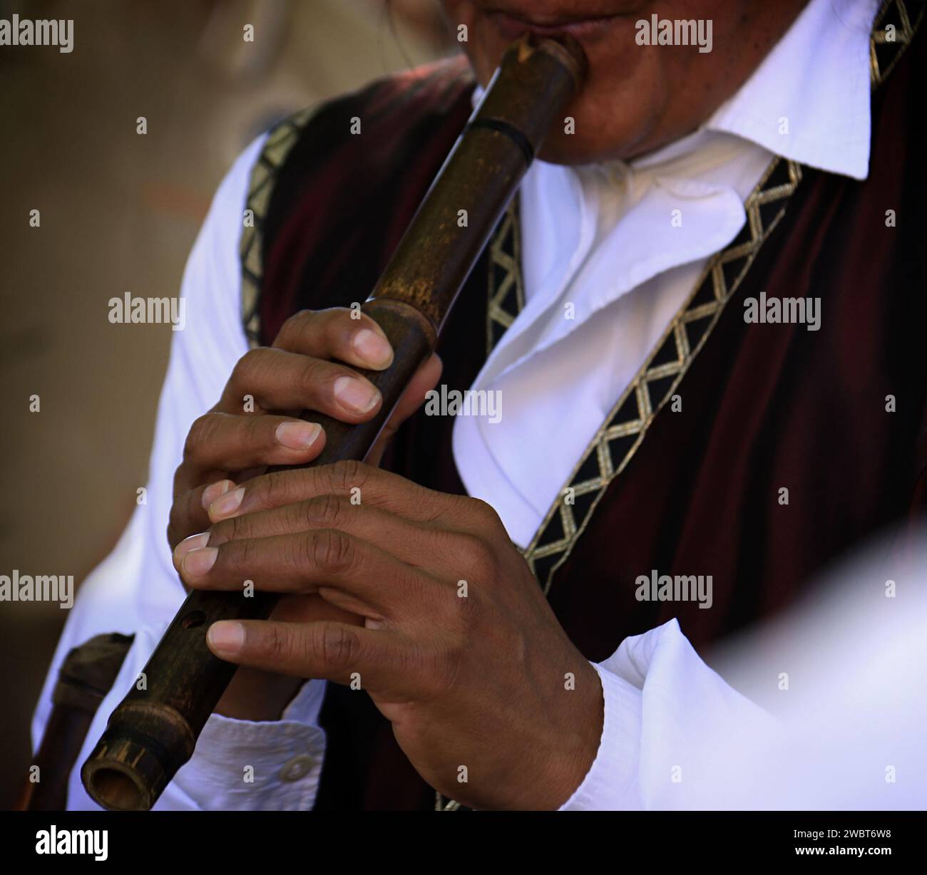 Un musicista che suona su un vecchio flauto. Foto Stock