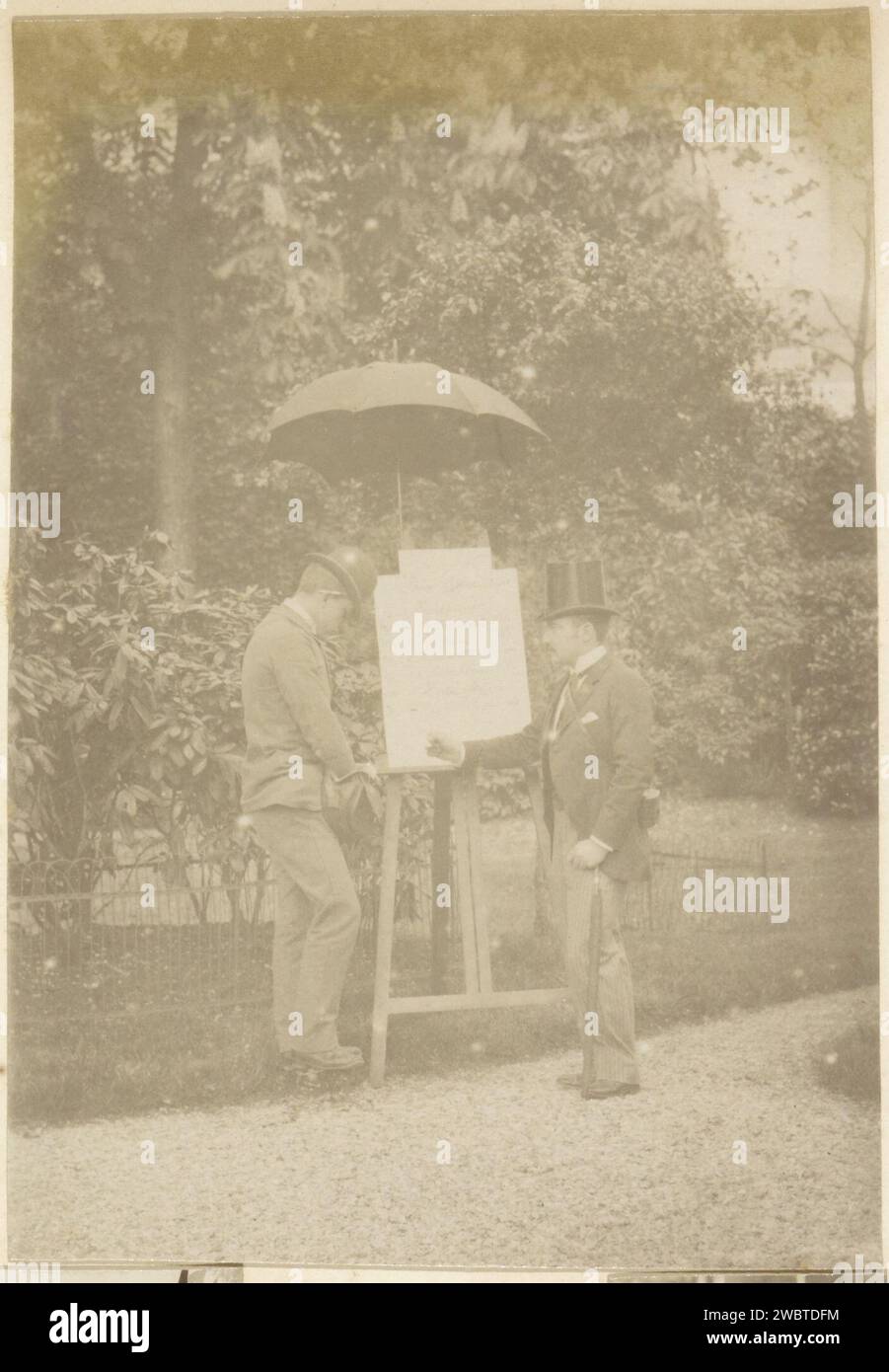 Due uomini francesi in piedi a un cavalletto in un giardino, c. 1900 - c. 1910 Fotografia parte di un album fotografico di un fotografo dilettante francese con registrazioni di una famiglia, Distillery Delizy & Doistau Fils, l'esercito e le attrazioni in Francia. Carta francese. supporto fotografico albume stampa uomo adulto. head-gear: cappello bowler. head-gear: cappello. cavalletto. Umbrella France Foto Stock