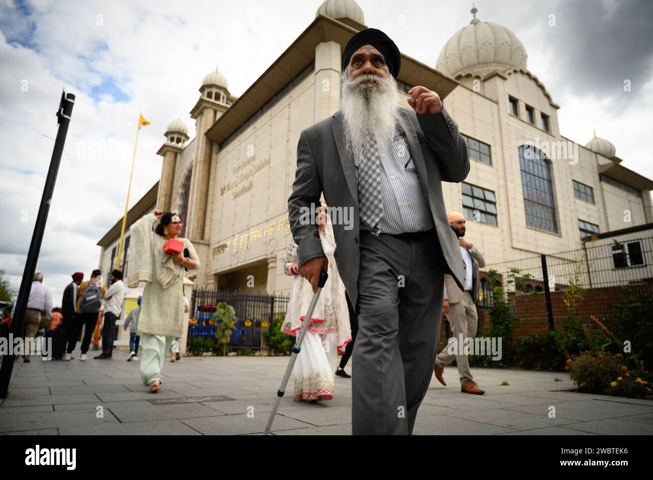 29 agosto 2022: Southall, nel quartiere di Ealing nella zona ovest di Londra, ospita la più grande comunità punjabi al di fuori del subcontinente indiano. È diventato un centro della cultura asiatica nel Regno Unito, spesso indicato come Little India. La fotografia mostra i fedeli sikh che passano davanti al tempio Gurdwara Sri Guru Singh Sabha. Foto Stock