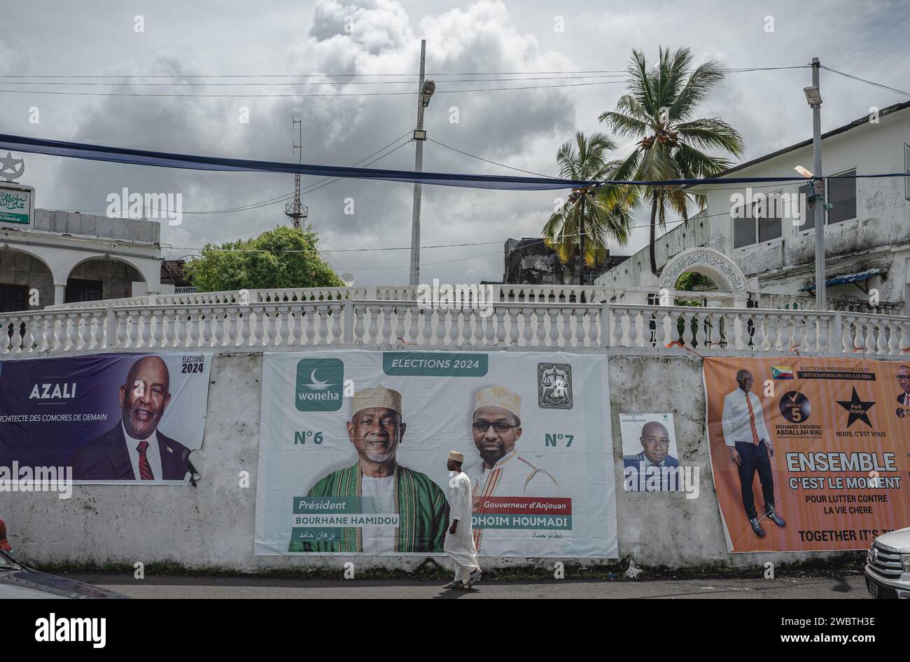 Moroni, Comore. 12 gennaio 2024. Un pedone passa i manifesti elettorali a Moroni, capitale delle Comore, 12 gennaio 2024. Le Comore daranno il via alle elezioni presidenziali domenica. Crediti: Wang Guansen/Xinhua/Alamy Live News Foto Stock