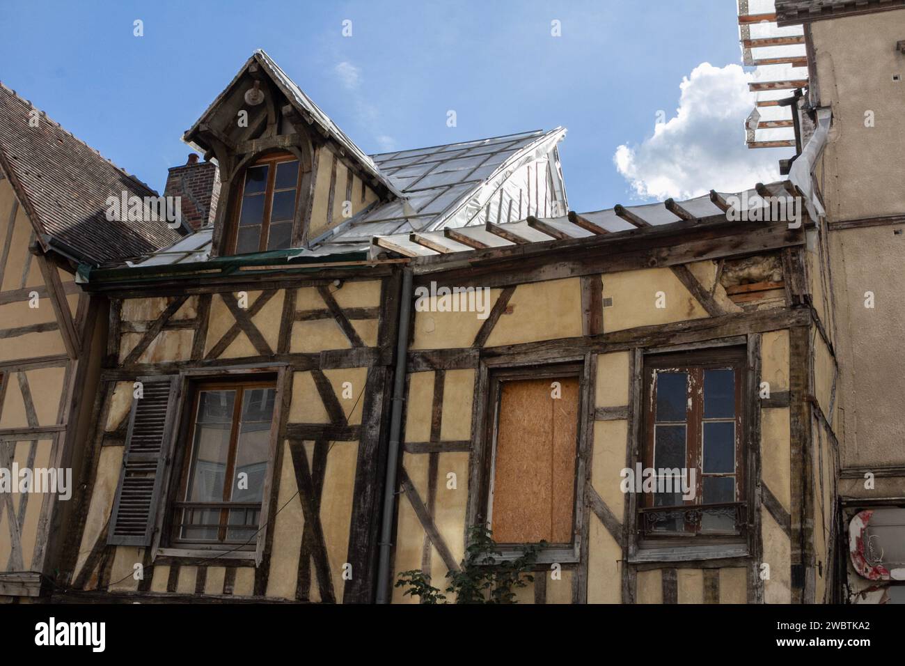 Case medievali con cornici in legno che necessitano di restauro all'estremità orientale, meno turistica, di rue Kléber nel centro storico di Troyes, in Francia. Foto Stock