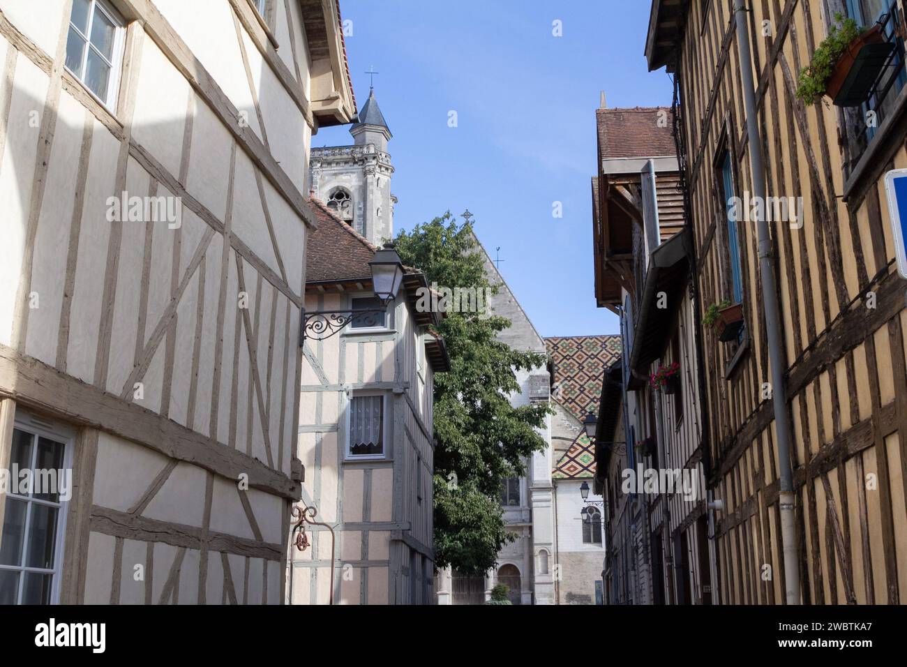 Case medioevali in legno sulla rue Albert Merat che conducono alla chiesa di St Nizier e al suo colorato tetto in piastrelle smaltate nella storica Troyes, in Francia. Foto Stock