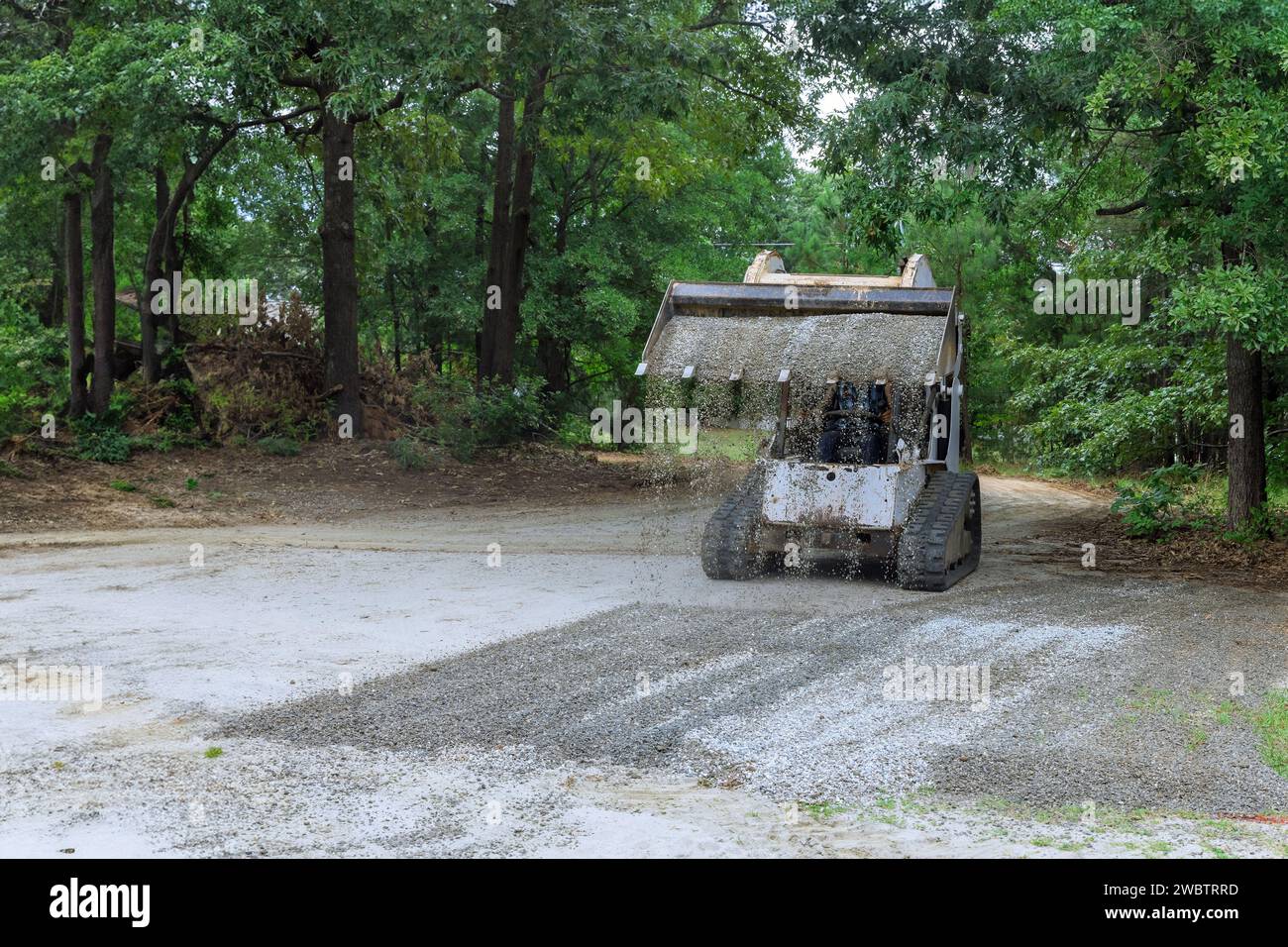 La minipala Bobcat sposta la benna di ghiaia frantumata durante le operazioni di costruzione Foto Stock