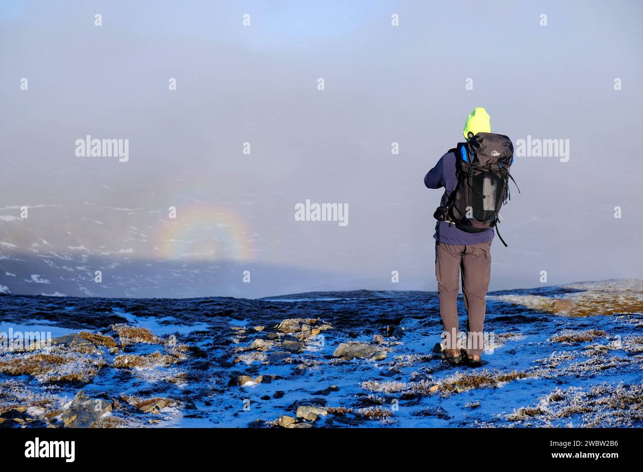 Drumochter, Scozia, Regno Unito. 12 gennaio 2024. Neve sui munros e inversioni di nuvole intorno alle valli di Drumochter attirando gli escursionisti per le passeggiate impegnative e creando panorami spettacolari. Escursionista che fotografa Un fenomeno meteorologico dello spettro di Brocken. Crediti: Craig Brown/Alamy Live News Foto Stock