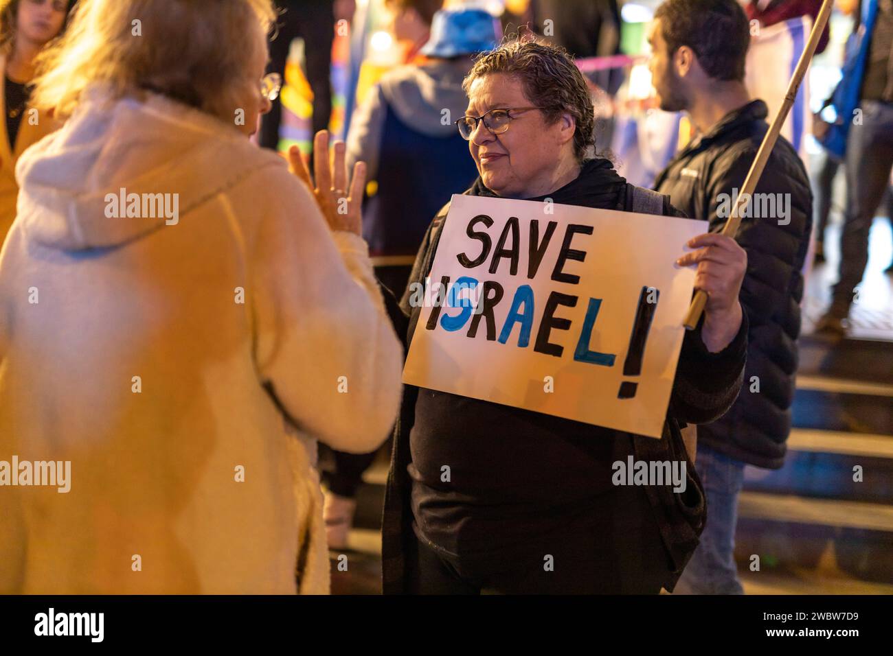 Haifa, Israele - 21 gennaio 2023: La gente protesta con segni contro i piani legislativi del nuovo governo. Una donna tiene una bandiera che dice Salva Foto Stock