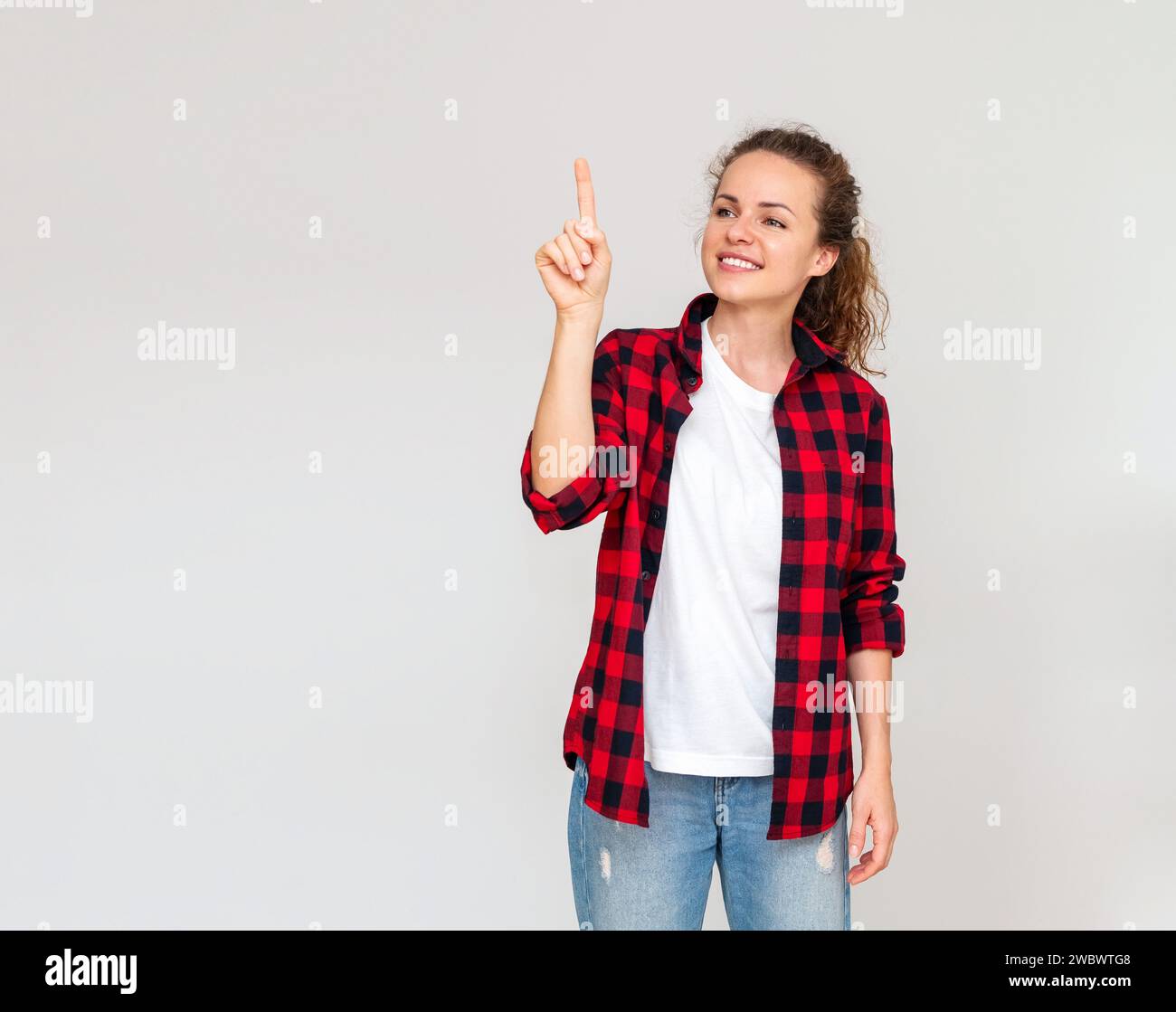 Sfondo mockup di una donna allegra che tocca lo schermo di proiezione virtuale con il dito. Shopping online. Servizio virtuale di eBanking. Selezionare un prodotto in Foto Stock