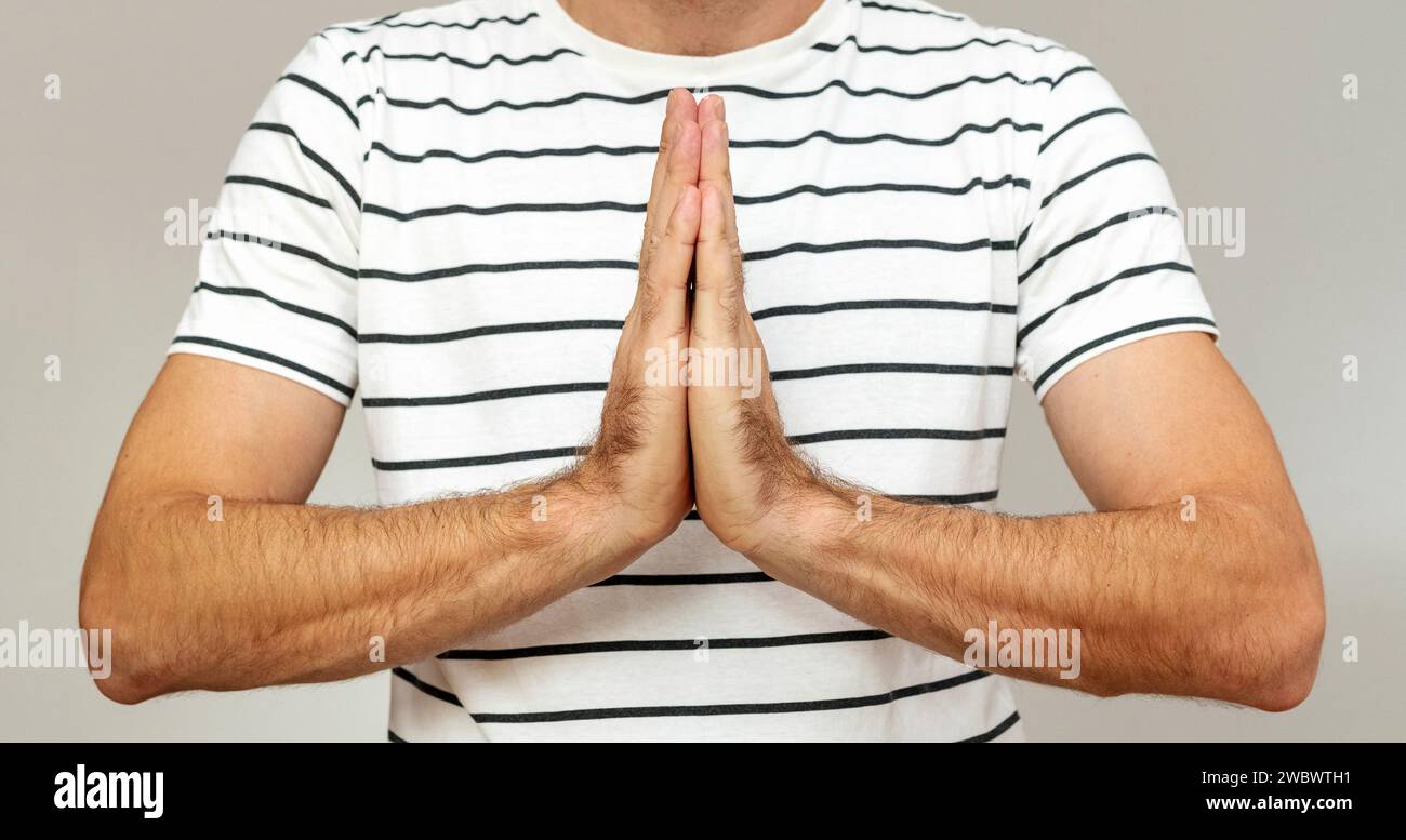 Concetto di preghiera e speranza. Persona maschile che tiene le mani in preghiera. Foto Stock