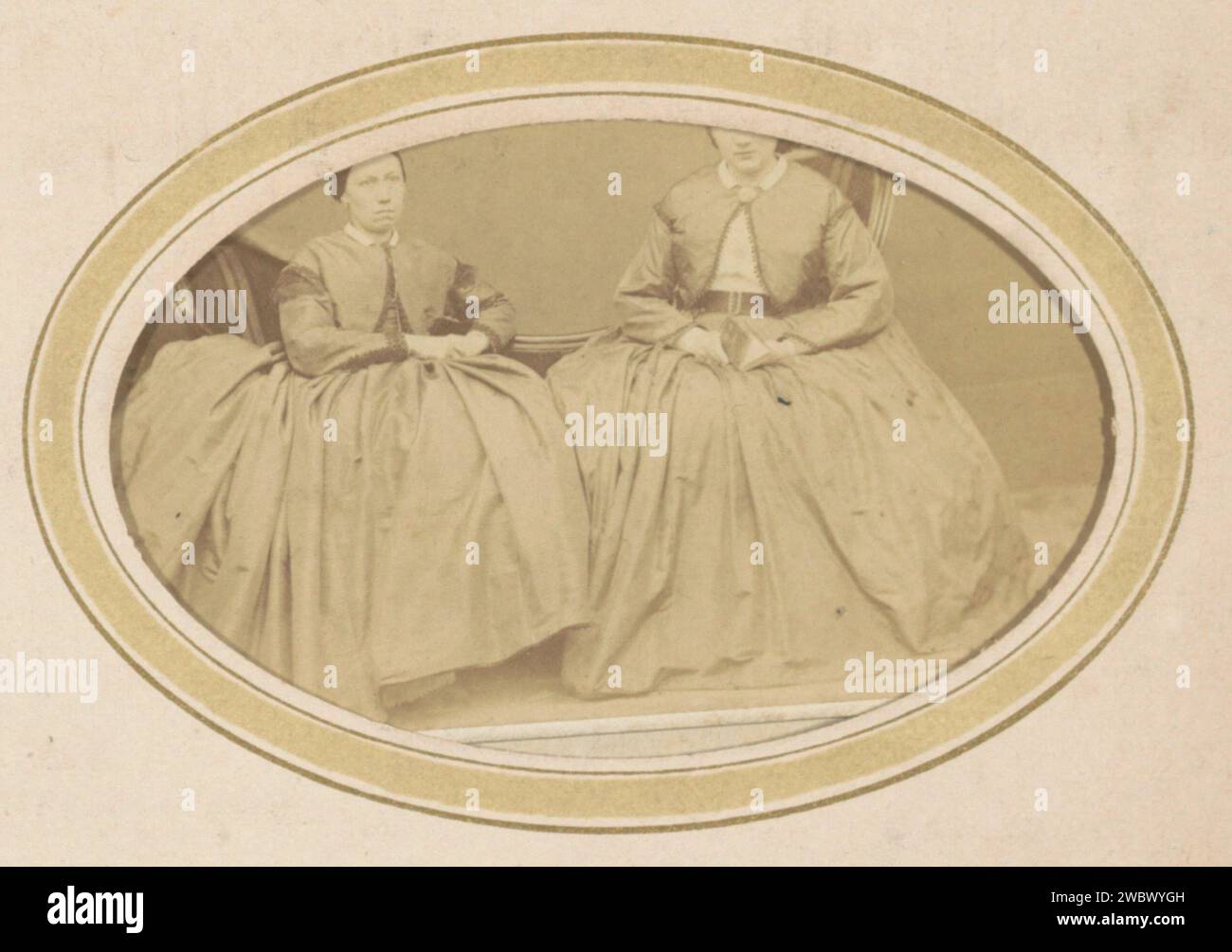 Ritratto di due donne con un bolero e una gonna larga, C. Janssens & E. Radermacher, 1868 - 1869 Fotografia. Visita la scheda parte dell'album fotografico di una famiglia olandese con 168 cartes de-visiting e foto di armadietti. Rotterdam cartone. carta. supporto fotografico per la stampa di persone storiche da parte di albumen. requisiti studio  fotografo. indumenti per la parte superiore del corpo. Stili di parrucchiere - AA -  donne. orecchie. gonna. Stili di parrucchiere - AA -  donne Rotterdam Foto Stock