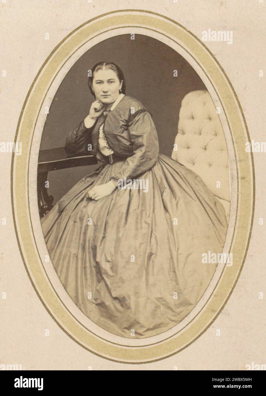 Ritratto di una donna con un bolero e una gonna larga, C. Janssens & E. Radermacher, 1868 - 1869 Fotografia. Visita la scheda parte dell'album fotografico di una famiglia olandese con 168 cartes de-visiting e foto di armadietti. Rotterdam cartone. carta. supporto fotografico per la stampa di persone storiche da parte di albumen. requisiti studio  fotografo. indumenti per la parte superiore del corpo. Stili di parrucchiere - AA -  donne. orecchie. gonna. Stili di parrucchiere - AA -  donne Rotterdam Foto Stock