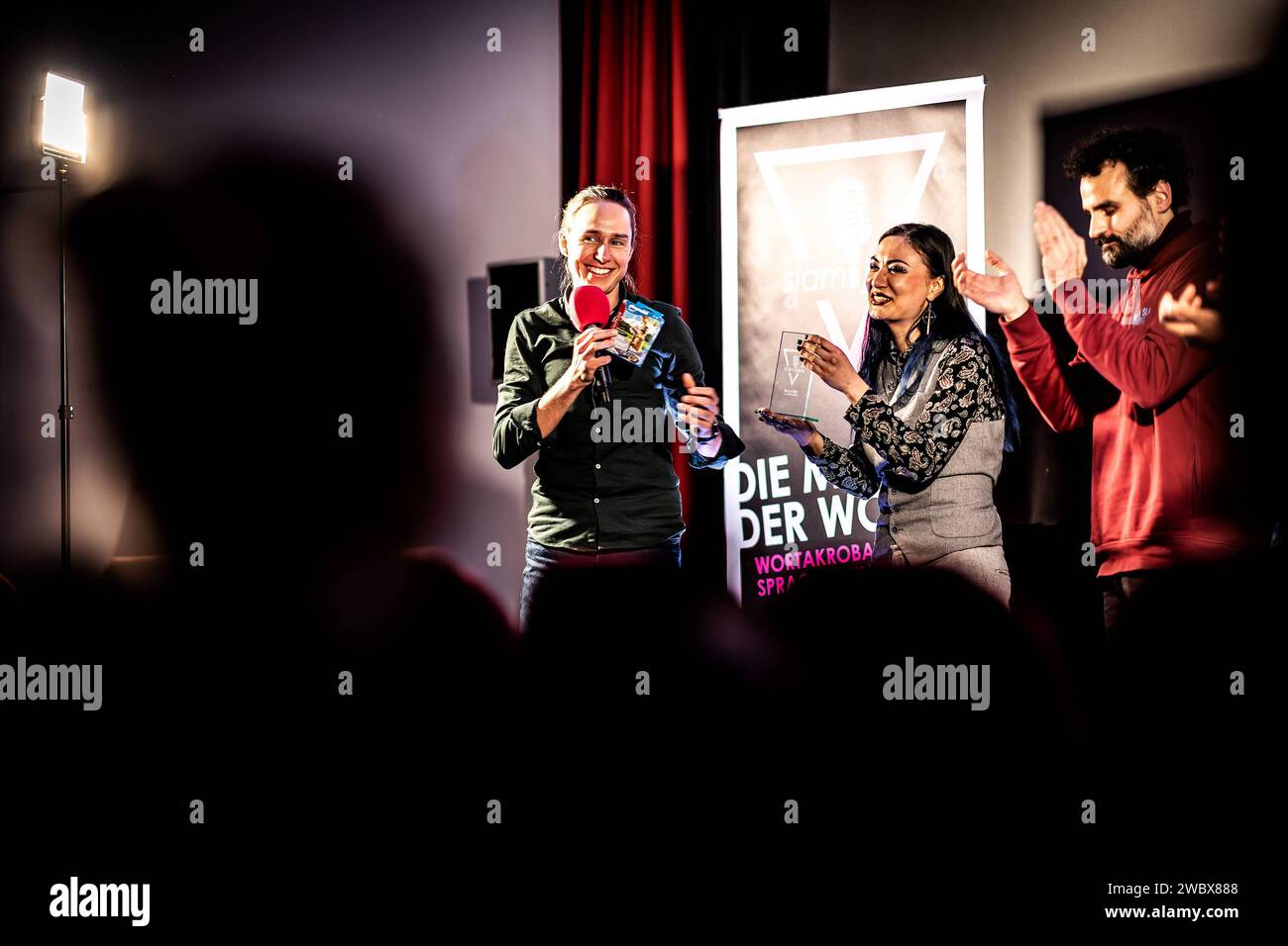 SLAM JAM - Die Poetry-Slam-Veranstaltungsreihe im Kreis Gross-Gerau Walldorf, 11.01.2024 Siegerehrung mit Moderator Sebastian Hauf, Siegerin des Poetry-Slam-Abends Aileen Schneider und Slammer Gregor Biberacher, der applaudiert SLAM JAM - Die Poetry-Slam-Veranstaltungsreihe im Kreis Gross-Gerau - Hessino Lichim Lessen 11.01.2024. Walldorf Kino Lichtblick Hessen Deutschland **** SLAM JAM la serie di eventi di poesia slam nel distretto di Gross Gerau Walldorf, 11 01 2024 cerimonia di premiazione con il presentatore Sebastian Hauf, vincitore della serata di poesia slam Aileen Schneider e Foto Stock