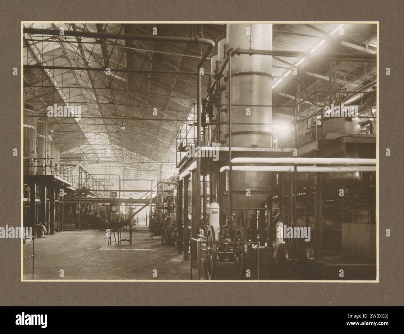 Sala con macchine della fabbrica di zucchero Goedo a Djombang su Java, c. 1925 - c. 1930 Fotografia parte dell'album fotografico con registrazioni di quattro fabbriche di zucchero su Java. Cartone Jombang. carta. supporto fotografico zucchero con stampa gelatina argento. piantagione. piante ed erbe: canna da zucchero. Interni di fabbrica, officina meccanica delle Indie Orientali olandesi, Jombang Foto Stock