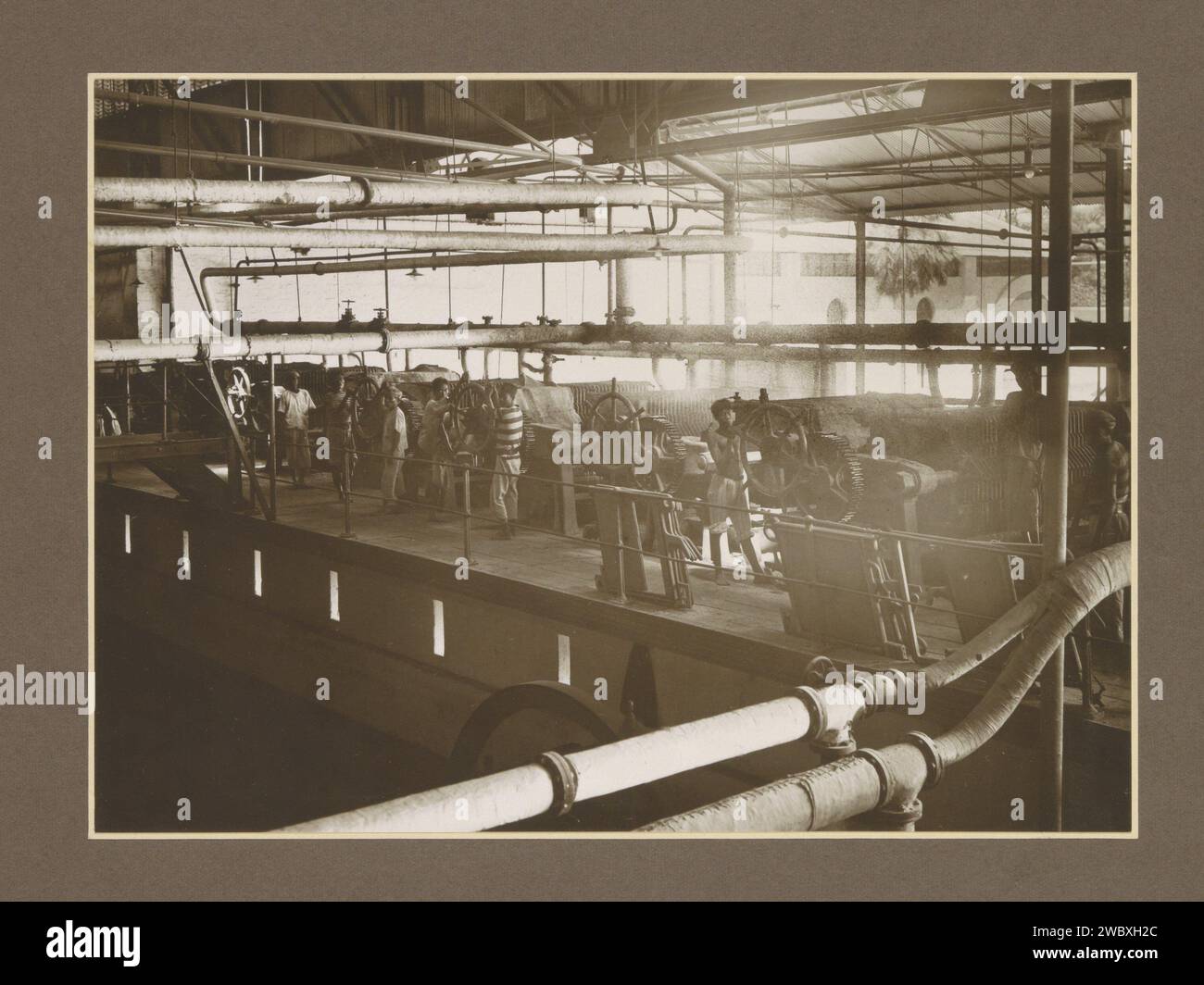 Dipendenti della stazione di filtrazione della fabbrica di zucchero Budoeran a Sidoarjo, a Java, c. 1925 - c. 1930 Fotografia parte dell'album fotografico con registrazioni di quattro fabbriche di zucchero a Java. Cartone Sidoarjo. carta. supporto fotografico zucchero con stampa gelatina argento. piantagione. piante ed erbe: canna da zucchero. Interni di fabbrica, officina meccanica delle Indie Orientali olandesi, Sidoarjo Foto Stock