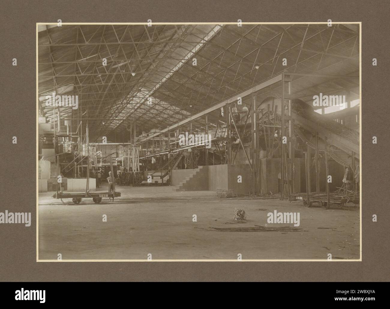 Zuccherifici e dipendenti in una sala della Sugar Factory Goedo a Djombang su Java, c. 1925 - c. 1930 Fotografia parte di album fotografico con registrazioni di quattro zuccherifici su Java. Cartone Jombang. carta. supporto fotografico zucchero con stampa gelatina argento. piantagione. piante ed erbe: canna da zucchero. interni di fabbrica, officina meccanica. Classe operaia, lavoratori delle Indie Orientali olandesi, la. Jombang Foto Stock