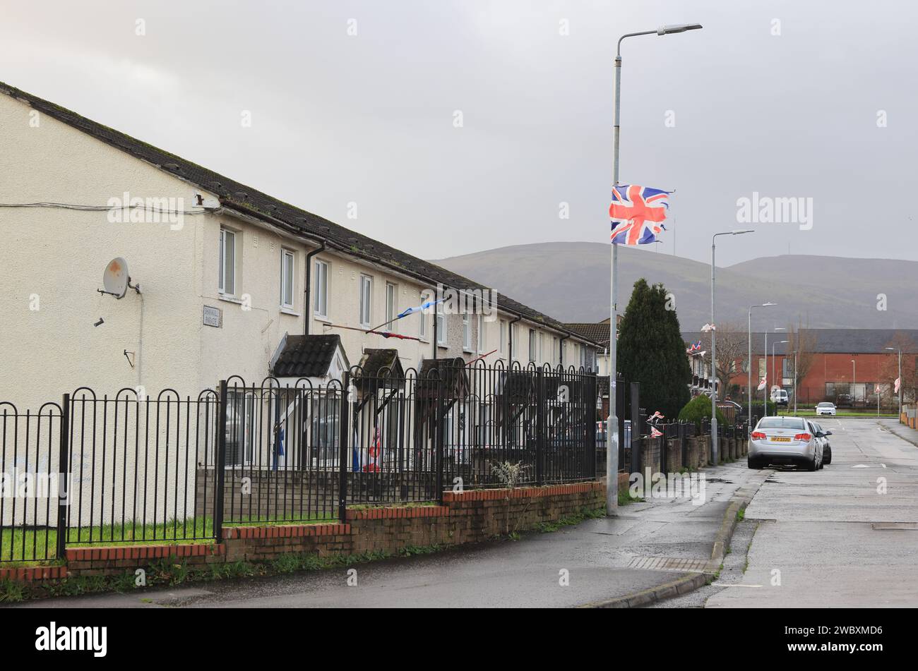 Union Jacks in volo nella tenuta Lower Shankill, nel lato lealista unionista di Belfast, NI, Regno Unito Foto Stock