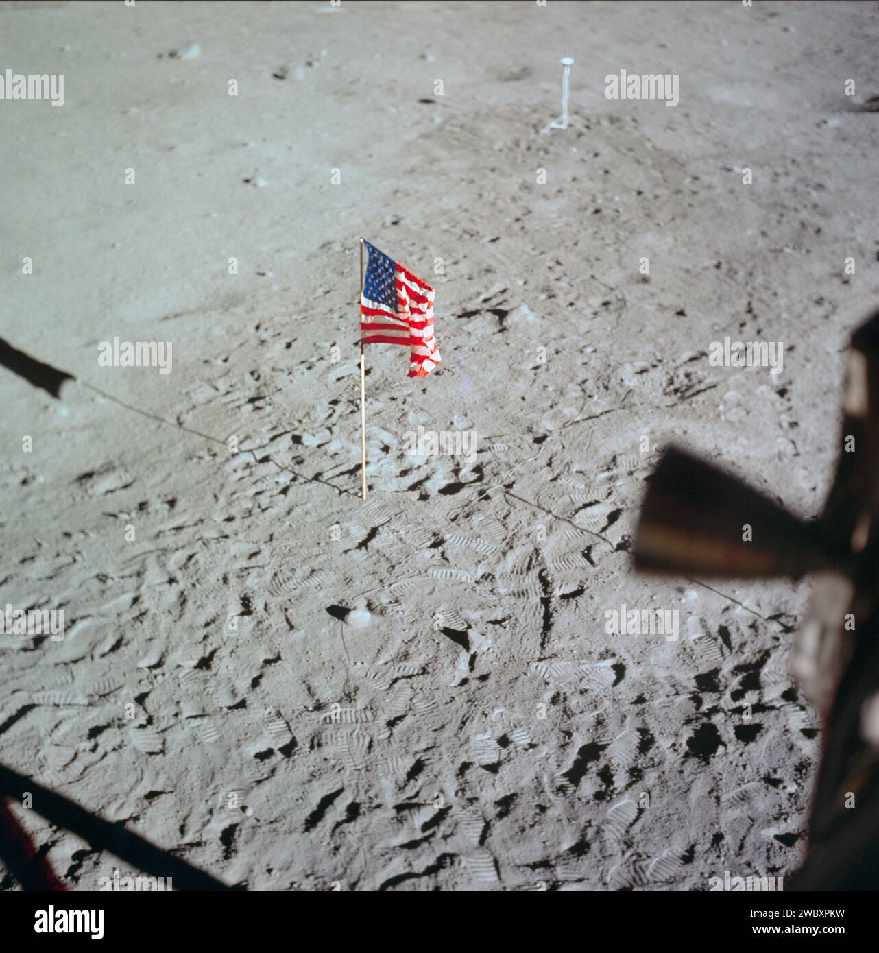 Bandiera degli Stati Uniti schierata sulla superficie lunare circondata dalle impronte degli astronauti Neil A. Armstrong ed Edwin E. Aldrin Jr., con telecamera di superficie lunare sullo sfondo, fotografata dall'interno del modulo lunare, Kennedy Space Center, NASA, 20 luglio 1969 Foto Stock