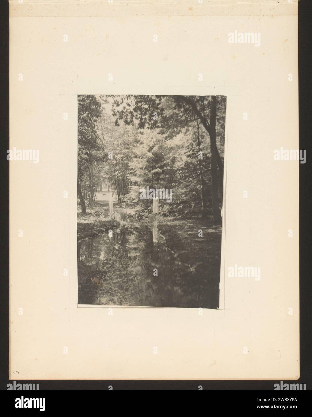 Veduta di un piccolo lago in una foresta, sulla riva c'è una persona con un abito bianco, Anonimo, 1900 - 1930 Fotografia questa foto fa parte di un album. supporto fotografico stampa gelatina argento foresta, legno. fen, Du. "ven". persone storiche Foto Stock