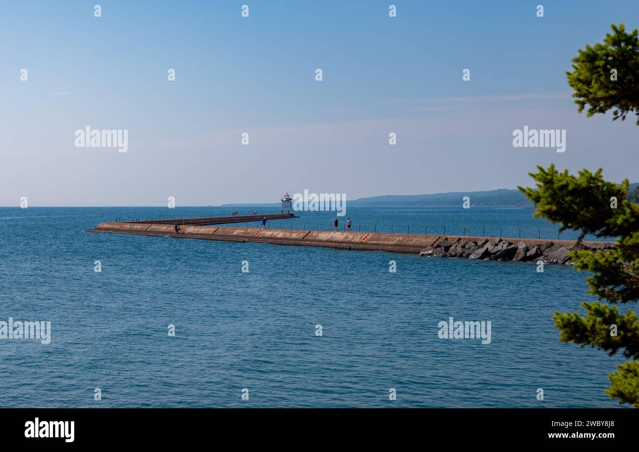 Una barriera di cemento per frangiflutti si getta nelle acque blu del lago superiore per proteggere il porto di Two Harbors, Minnesota. Foto Stock