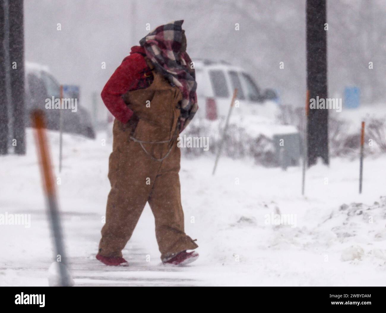 Altoona, Stati Uniti. 12 gennaio 2024. Un uomo cammina attraverso un parcheggio innevato mentre una tempesta invernale colpisce la zona, facendo scendere le temperature fino a livelli estremi di surgelamento ad Altoona, Iowa, venerdì 12 gennaio 2024. I candidati presidenziali repubblicani che hanno fatto campagna per l'Iowa Caucus sono stati costretti a cancellare gli eventi a causa delle pericolose condizioni meteorologiche. Gli elettori repubblicani dell'Iowa si riuniranno a caucus il 15 gennaio per selezionare il loro candidato alla presidenza degli Stati Uniti. Foto di Tannen Maury/UPI Credit: UPI/Alamy Live News Foto Stock