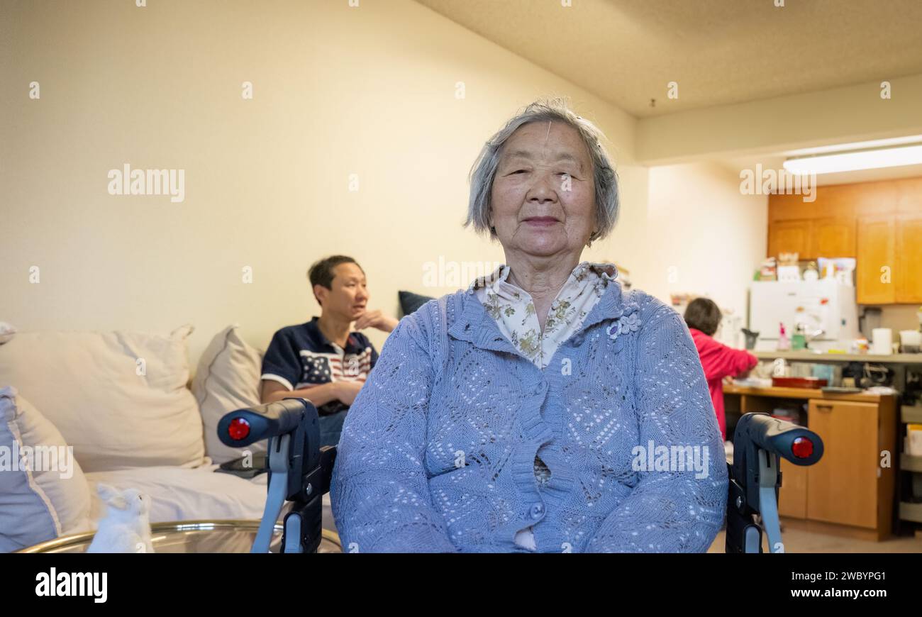 Donna anziana che riceve la terapia di agopuntura a casa con aghi sulla fronte. Foto Stock