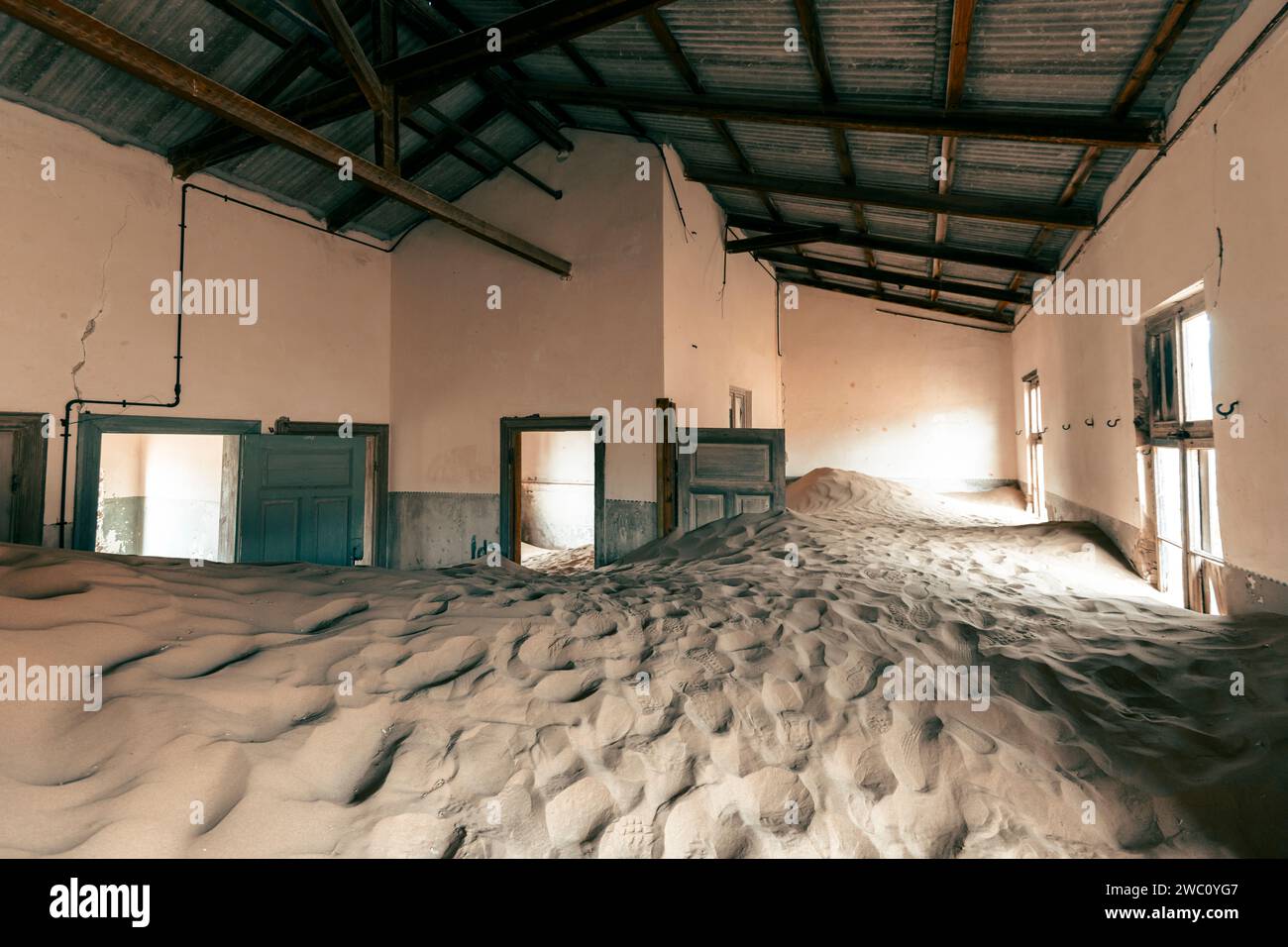 La sabbia del deserto copre completamente l'interno di una delle molte proprietà abbandonate dell'antica città fantasma di Kolmanskop nel sud della Namibia Foto Stock