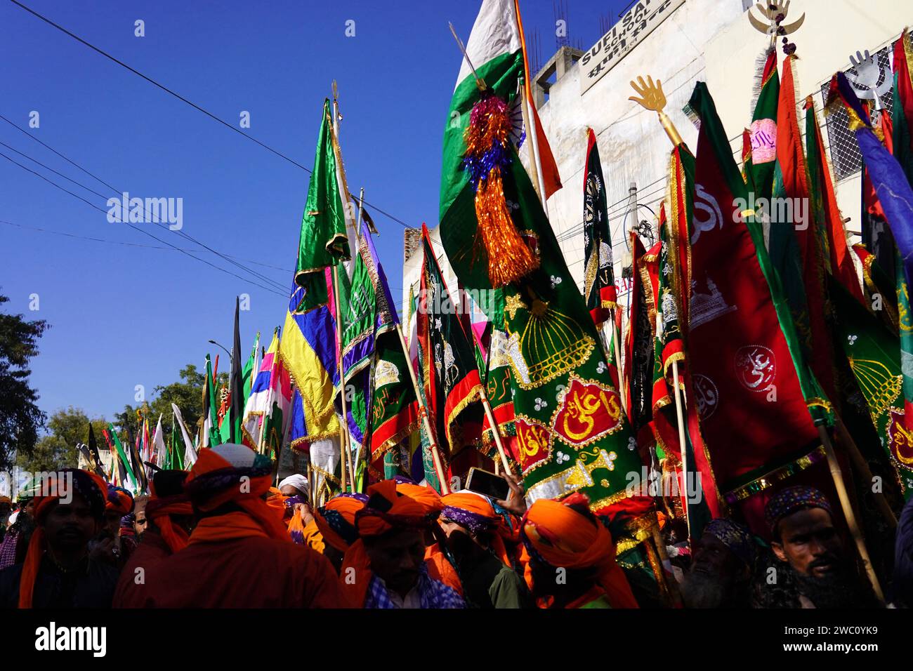 Ajmer, India. 13 gennaio 2024. I devoti musulmani indiani portano bandiere sacre durante la processione religiosa per l'annuale festa degli urs presso il santuario di santa Hazrat Khwaja Moinuddin Chishti ad Ajmer Rajasthan India il 12 gennaio 2024. Migliaia di devoti sufi provenienti da diverse parti dell'India si recano al santuario per il festival annuale, in occasione dell'anniversario della morte del santo. Foto di ABACAPRESS.COM Credit: Abaca Press/Alamy Live News Foto Stock