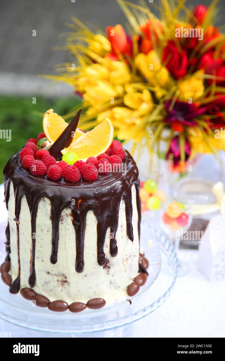 Festa di compleanno per bambini. Un tavolo festivo decorato con torta di compleanno con fiori e dolci. Foto Stock