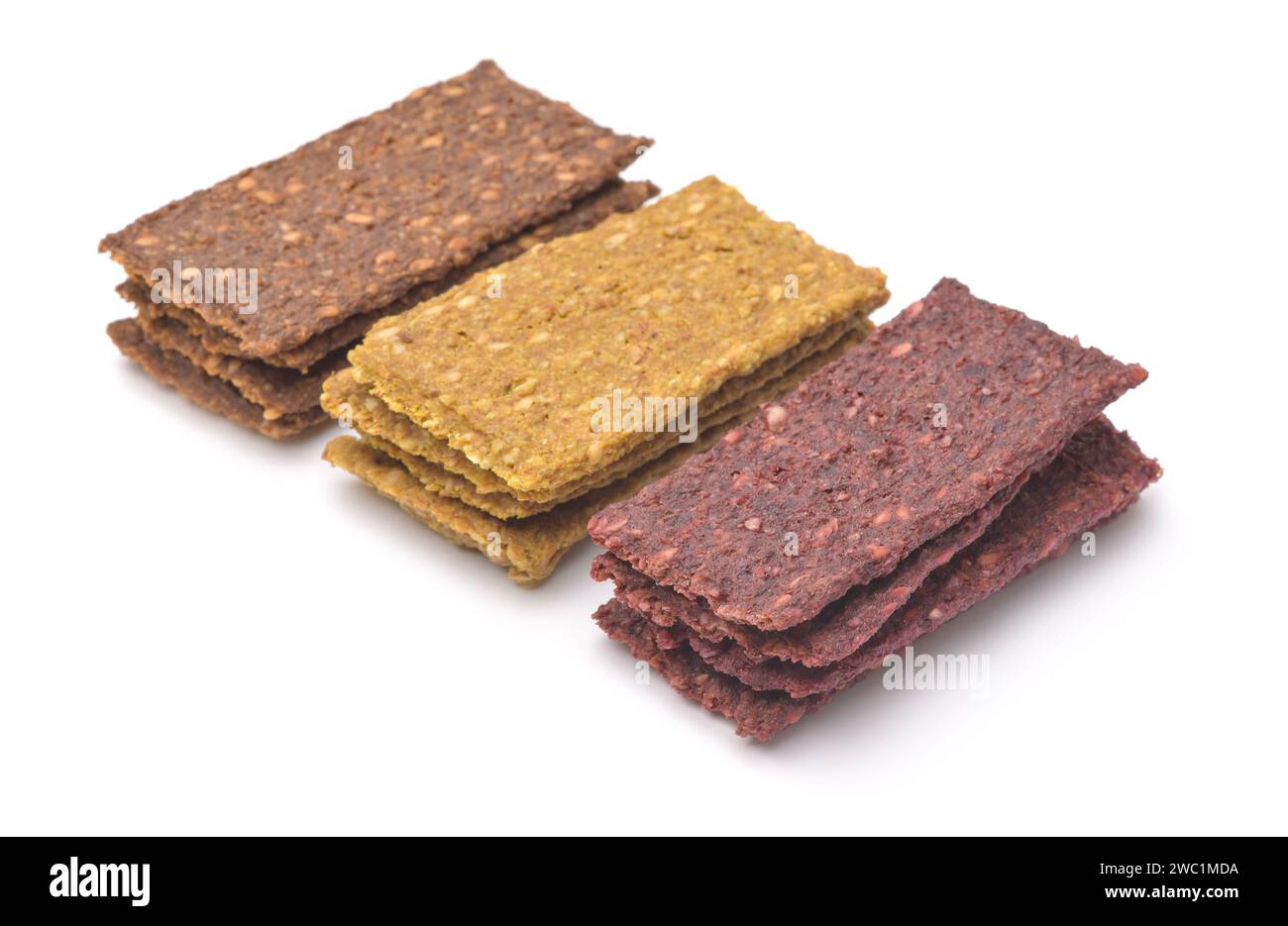 Pile di diversi tipi di pane croccante vegetale naturale con semi di sesamo isolati su bianco Foto Stock