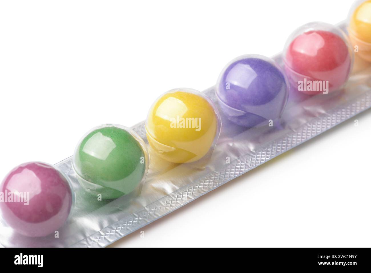 Primo piano delle colorate palle di gomma da masticare in stick pack su sfondo bianco Foto Stock