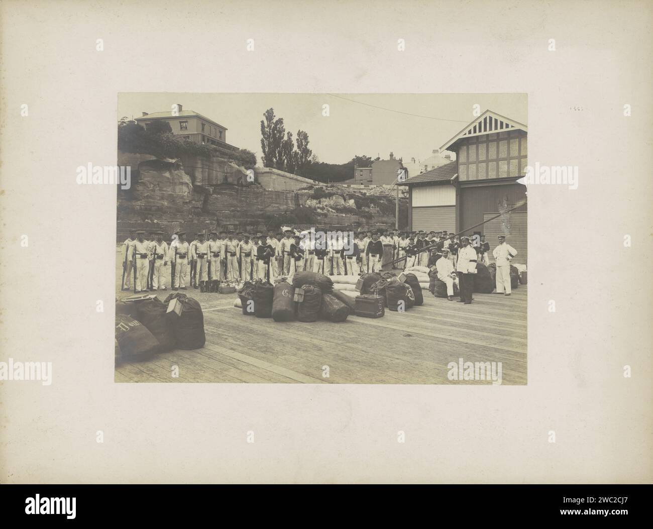 Marines con sacchetti a riva, presumibilmente a Sydney, Anonimo, c. 1890 - c. 1910 Fotografia parte di Reisalbum con foto di luoghi di interesse turistico di Sydney. Cartone di Sydney. carta. supporto fotografico banchina con stampa in argento gelatina (+ city(-scape) con figure, personale). marinaio (+ armi) Sydney Foto Stock