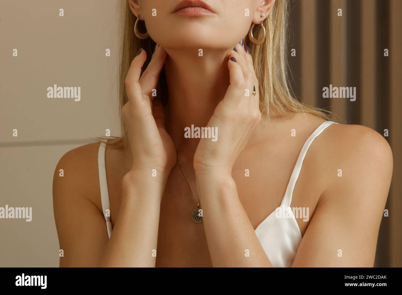 Donna caucasica che si tocca la gola. Mal di gola, raffreddore, influenza, tonsillite o problema della ghiandola tiroidea Foto Stock