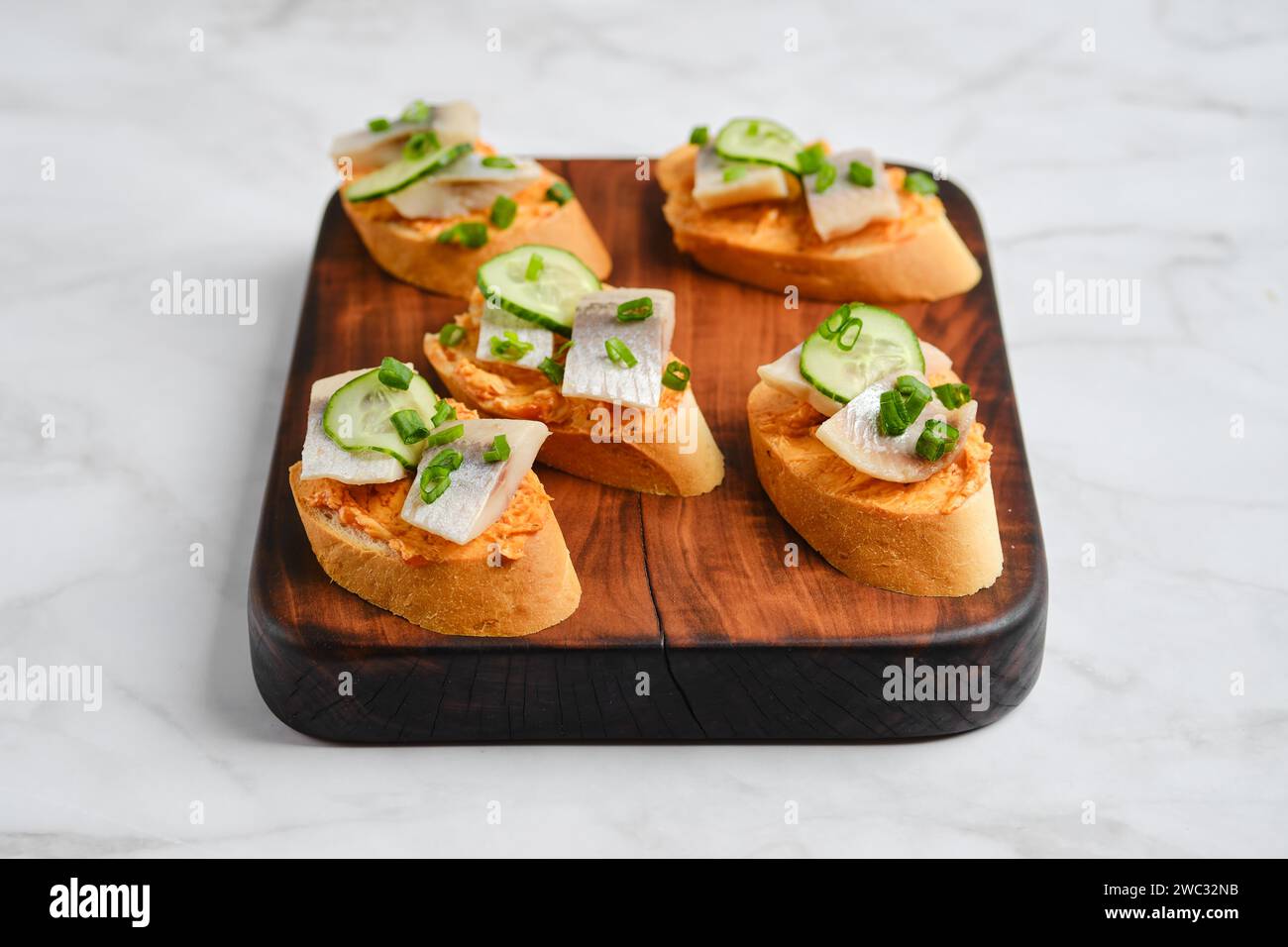 Piccoli panini con pezzi di Clupeidae e cipolla primaverile Foto Stock