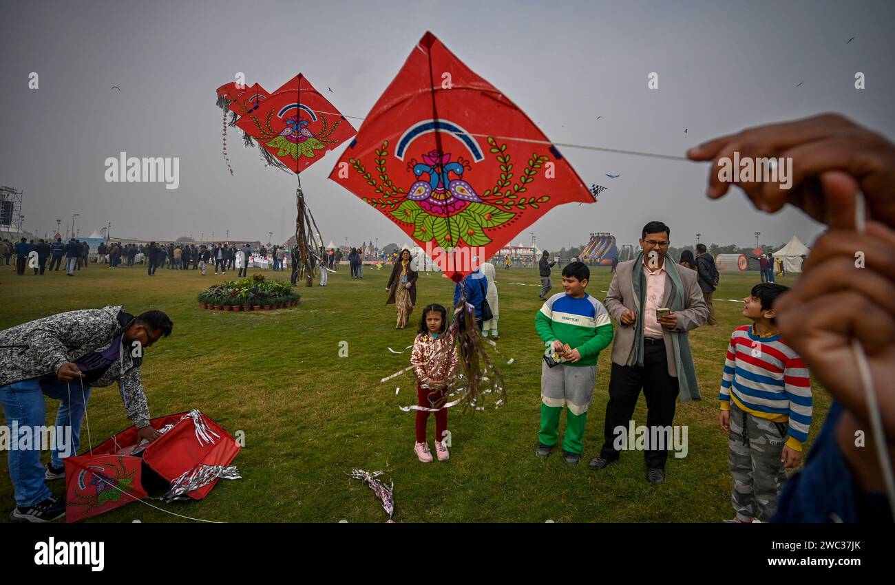 NUOVA DELHI, INDIA - 13 GENNAIO: Persone che volano aquiloni durante il primo festival internazionale degli aquiloni - "Patang Utsav" a Baansera, il primo parco a tema di bambù della città a sarai Kale Khan sulle rive del fiume Yamuna, il 13 gennaio 2024 a nuova Delhi, India. Il festival di due giorni è organizzato dalla Delhi Development Authority (DDA) e vedrà oltre 30 kitisti professionisti provenienti da Rajasthan, Sikkim, Maharashtra, Karnataka, Punjab, Lakshadweep e Gujarat espongono la loro arte. Aquiloni di varie forme, dimensioni e colori. (Foto di Raj K Raj/Hindustan Times/Sipa USA ) Foto Stock