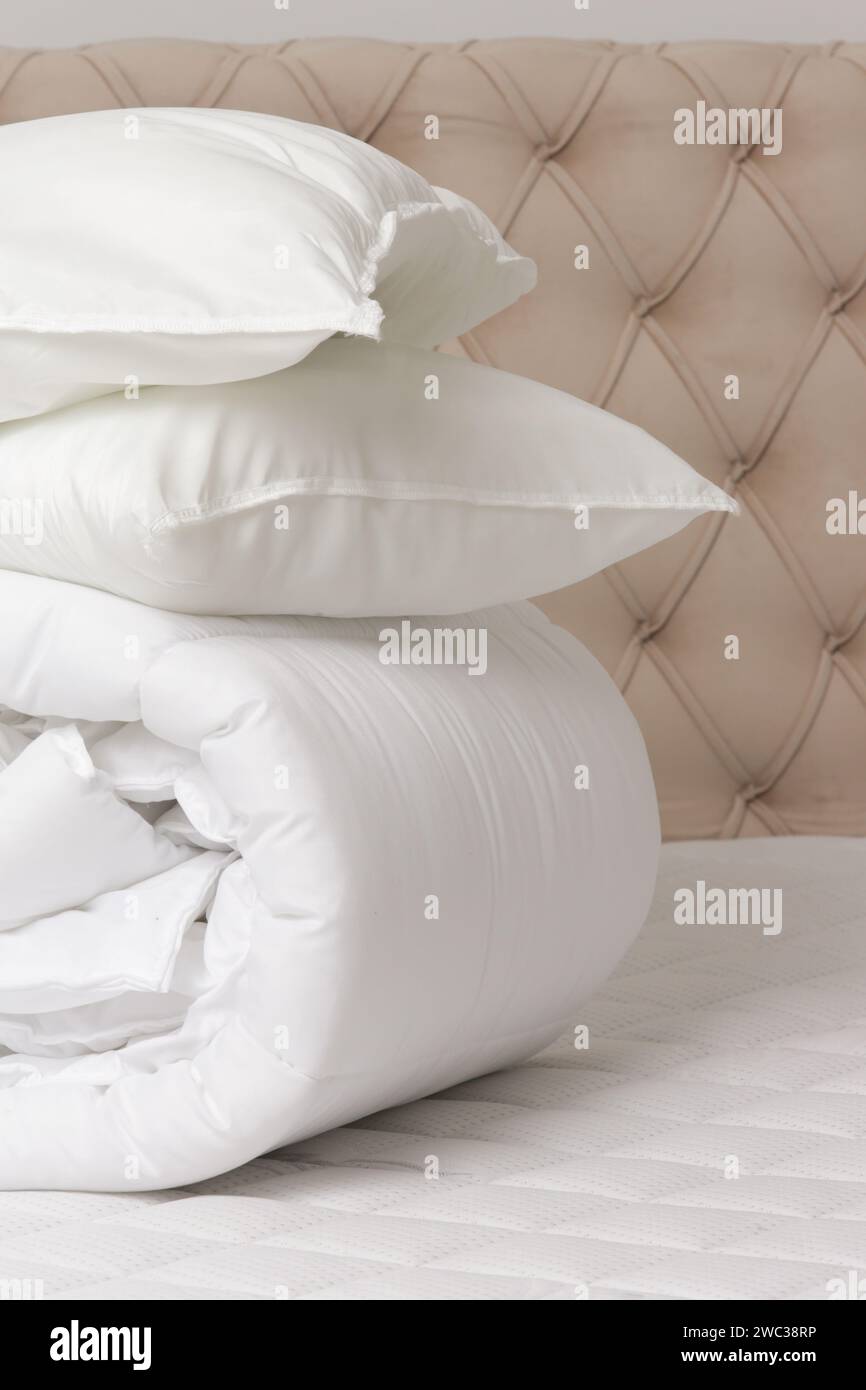 Soffici piumoni e cuscini ripiegati sul letto Foto Stock