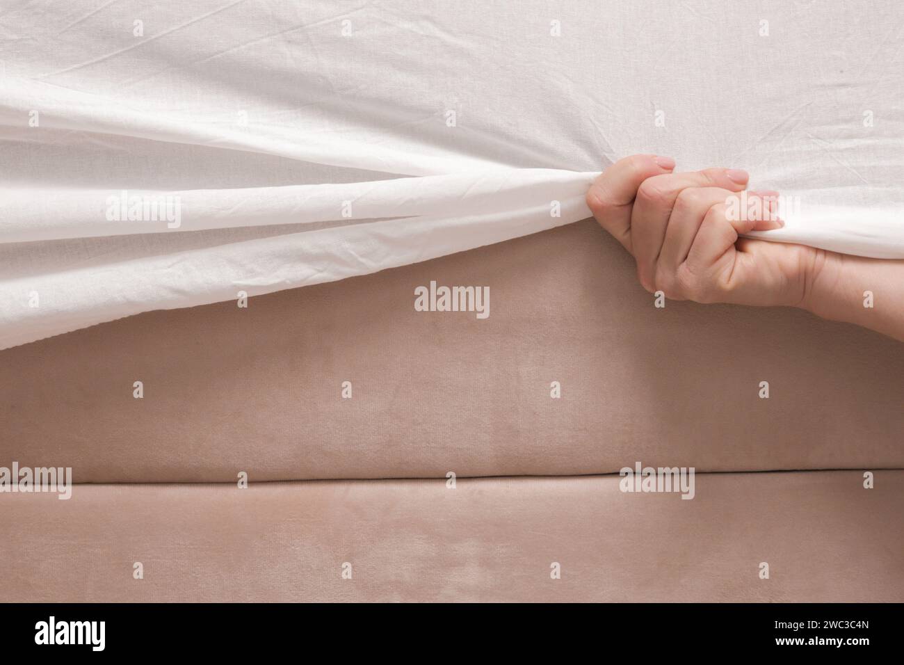 Cambio delle lenzuola. La donna sta indossando un lenzuolo di cotone bianco su un materasso durante la preparazione del letto. Foto Stock