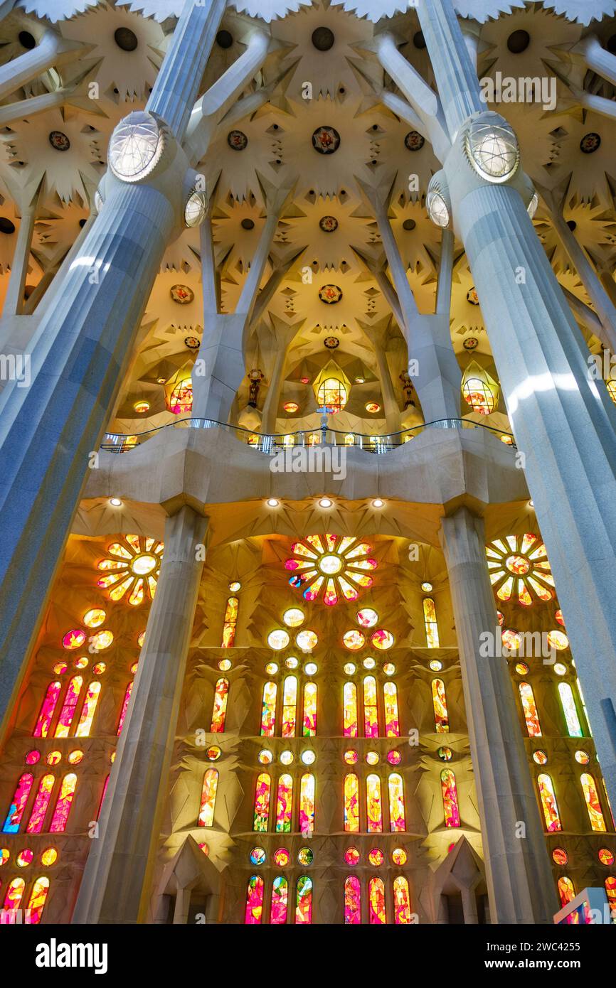 Vista dall'interno a basso angolo della luce che brilla attraverso le vetrate colorate all'interno della Basilica la Sagrada Familia, di Antoni Gaudí, Barcellona, Spagna Foto Stock