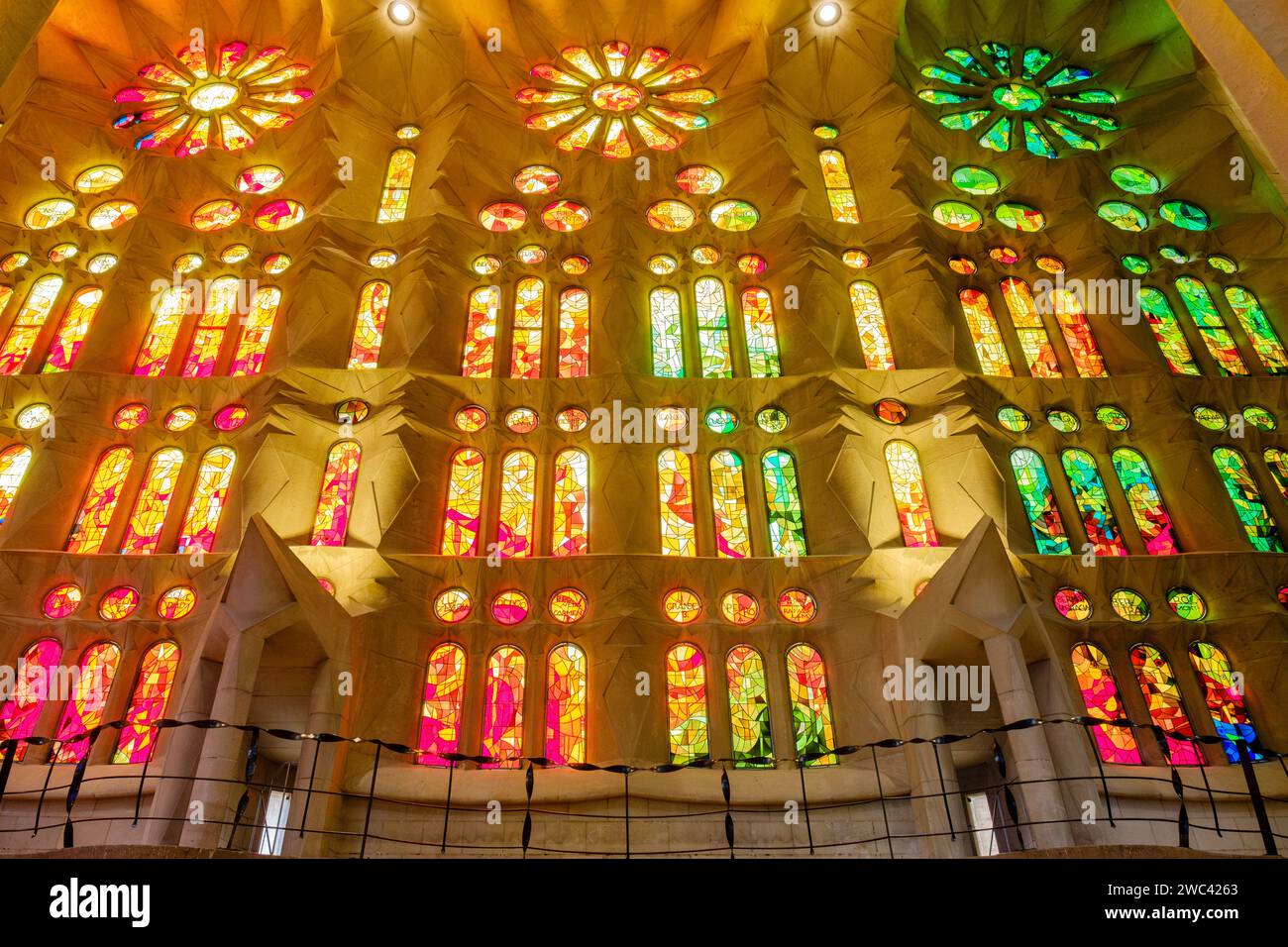 Vista dall'interno a basso angolo della luce che brilla attraverso le vetrate colorate all'interno della Basilica la Sagrada Familia, di Antoni Gaudí, Barcellona, Spagna Foto Stock