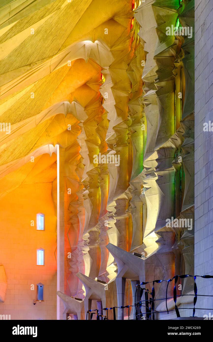 Luce interna che brilla attraverso le vetrate colorate progettate all'interno della Basilica la Sagrada Familia, di Antoni Gaudí, Barcellona, Spagna Foto Stock