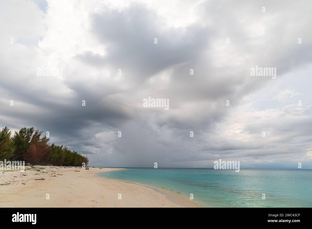 Nuvole di tempesta che si aprono su una spiaggia tropicale deserta Foto Stock